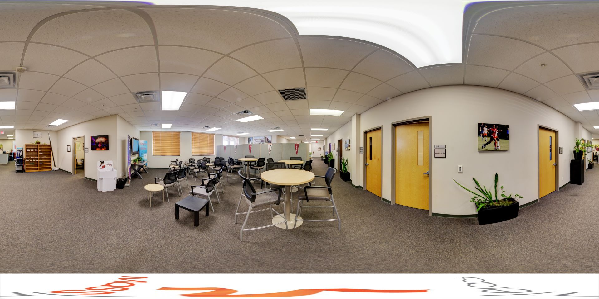 Office area in the L3Harris Commons at Florida Tech, equipped with various seating arrangements and adorned with sports memorabilia on the walls
